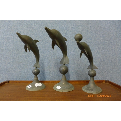 306 - Three brass dolphin ornaments