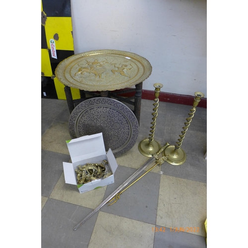 319 - An eastern brass topped folding occasional table, pair of brass barley twist candlesticks, etc