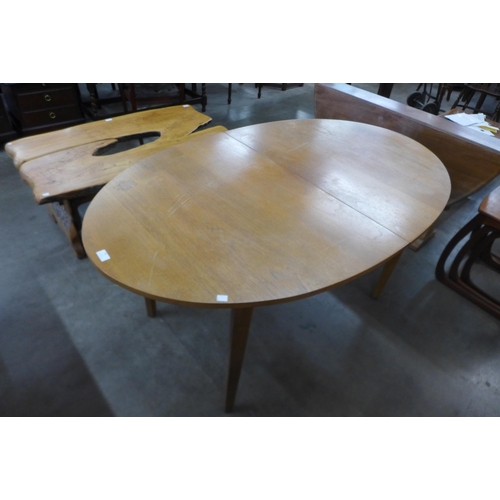 59 - An oval teak extending dining table