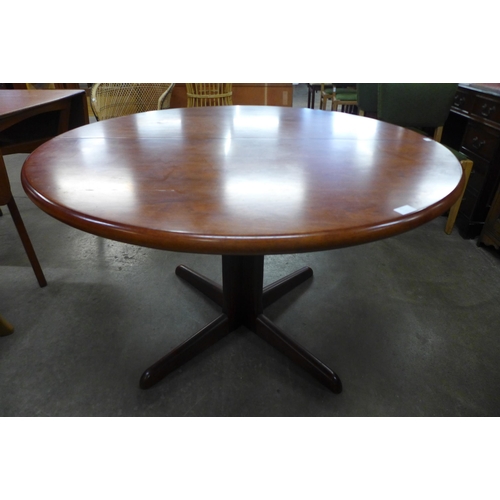 71 - A circular teak dining table