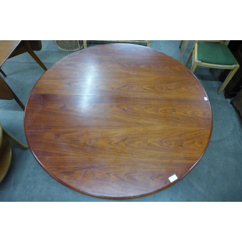 71 - A circular teak dining table