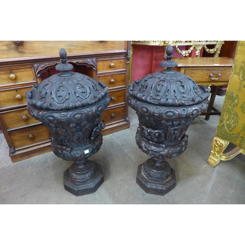 9 - A pair of large faux wood campana shaped urns and covers, decorated with Bacchanalian cherubs