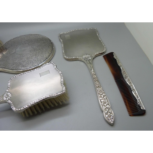 852 - A silver backed hand mirror with two matching brushes, one other silver backed hand mirror and a sil... 