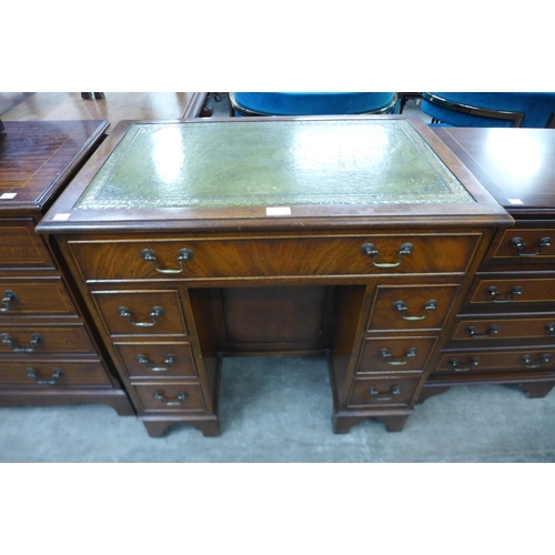 100 - A mahogany and green leather topped kneehole desk