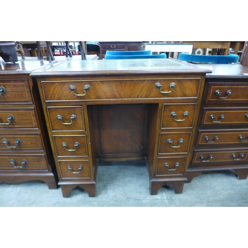 100 - A mahogany and green leather topped kneehole desk