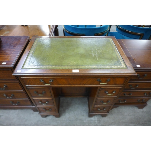 100 - A mahogany and green leather topped kneehole desk