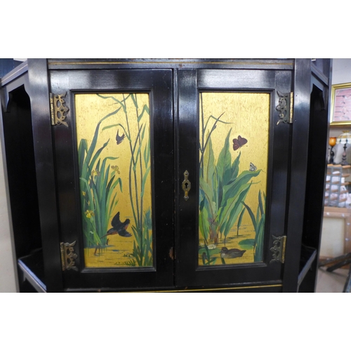 125 - A Victorian Aesthetic Movement ebonised and painted freestanding corner cabinet