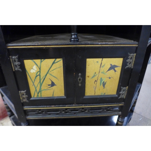 125 - A Victorian Aesthetic Movement ebonised and painted freestanding corner cabinet