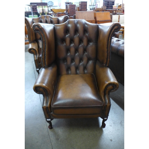 2 - A chestnut brown leather Chesterfield wingback armchair