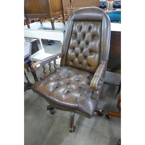 207 - A mahogany and brown leather revolving desk chair