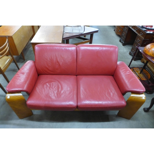 73 - A Norweigan Ekornes Stressless beech and red leather Pegasus settee, 81cms h, 166cms w, 85cms d