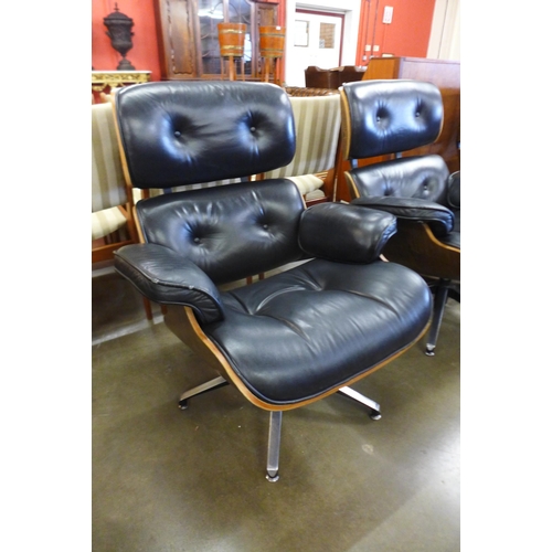 90 - A pair of Charles & Ray Eames style black leather, simulated rosewood and chrome revolving lounge ch... 