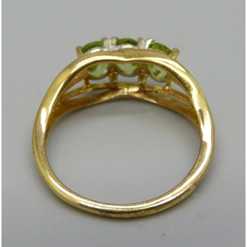 1009 - A silver-gilt peridot trilogy ring, O