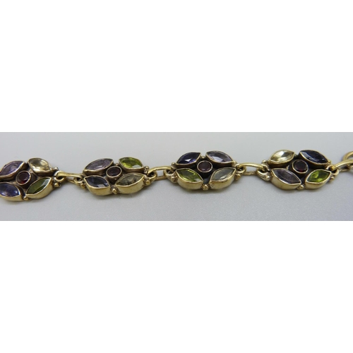 1021 - A multi gem set bracelet; peridot, amethyst, garnet and citrine