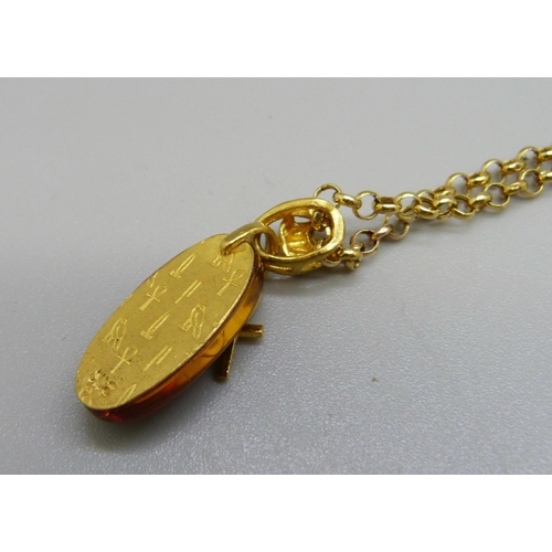 1035 - An Egyptian amber and 9ct gold pendant and chain, 5.4g