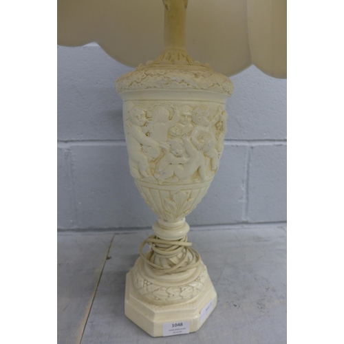 1048 - A table lamp decorated with cherubs **PLEASE NOTE THIS LOT IS NOT ELIGIBLE FOR POSTING AND PACKING**