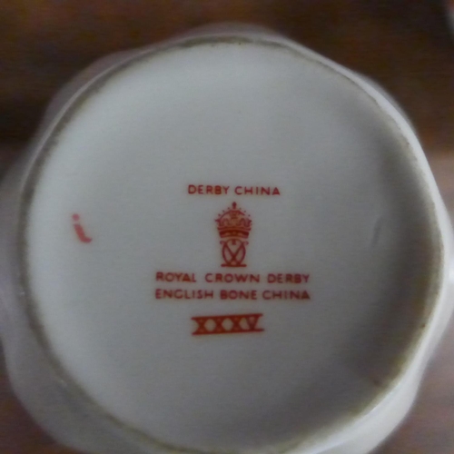 677 - Royal Crown Derby china; cups, plates and a bottle opener, some boxed