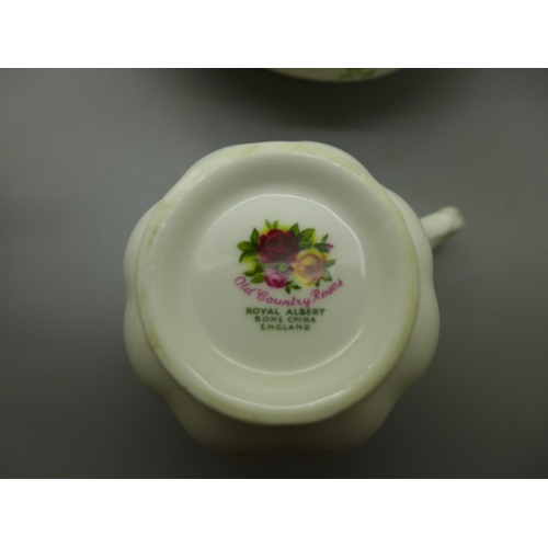 680 - Two Royal Albert Old Country Roses tea pots, a tea cup, cream and sugar, chip to base and crack on s... 