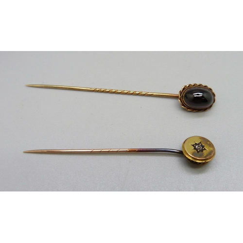 976 - Two yellow metal stick pins, one with cabachon stone, the other set with a diamond, 5.7g