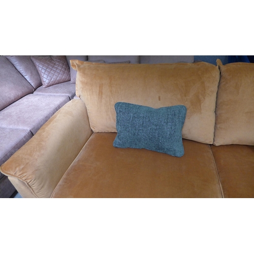 1560 - An ochre velvet four seater sofa with green scatter cushions and stainless steel legs