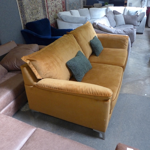 1560 - An ochre velvet four seater sofa with green scatter cushions and stainless steel legs