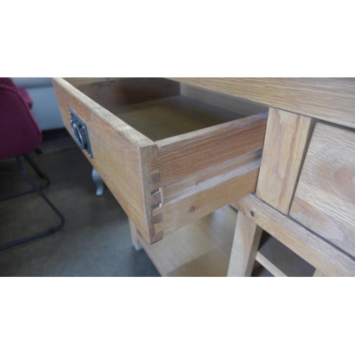 1569 - An oak three drawer wine sideboard