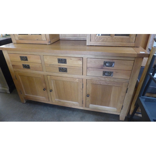 1570 - An oak three door, three drawer sideboard with dresser top