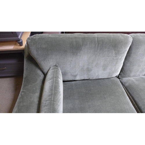 1648 - A forest green velvet three seater sofa (damaged under frame)