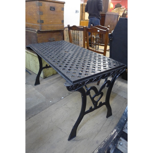 597 - A cast iron garden table and two chairs