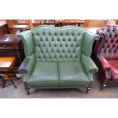 135 - A green leather Chesterfield settee