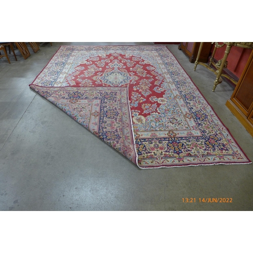 164 - An Iranian hand knotted red ground rug