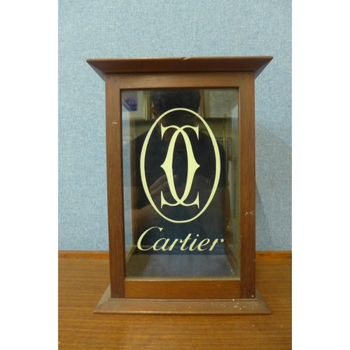 406 - An oak counter top shop cabinet, bearing Cartier inscription to door