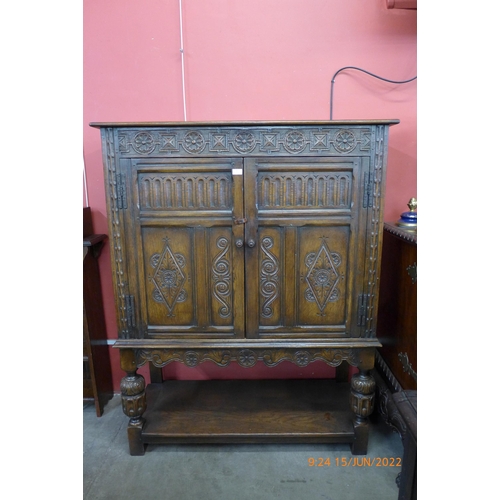 6 - An Elizabethan Revival carved oak two door livery cupboard