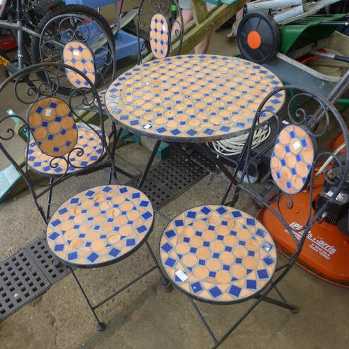 2321 - A 1 metre diameter circular mosaic topped garden table and four chairs