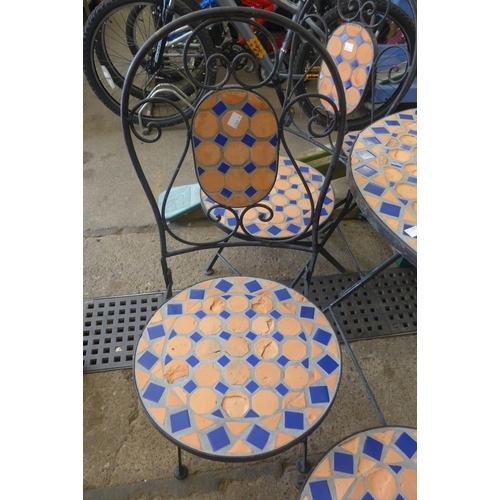 2321 - A 1 metre diameter circular mosaic topped garden table and four chairs