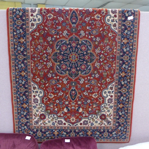 1573 - A floral patterned red ground Turkish woolen rug, 120x170cm