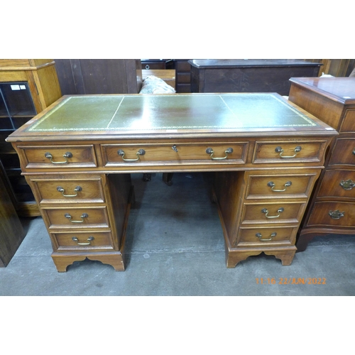 105 - A yew wood and green leather topped pedestal desk