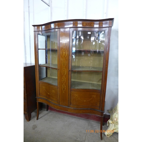 114 - An Edward VII inlaid mahogany serpentine two door display cabinet