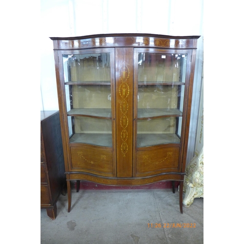 114 - An Edward VII inlaid mahogany serpentine two door display cabinet