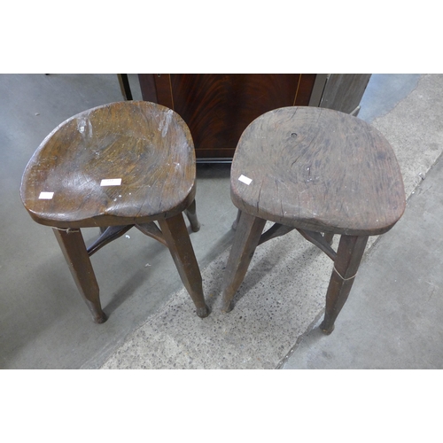 217 - A pair of elm and mahogany saddle seat kitchen stools