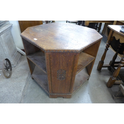 249 - An early 20th Century Heals style carved oak octagonal table/bookcase