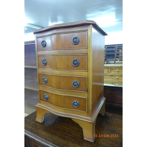 98 - A small yew wood serpentine chest of drawers