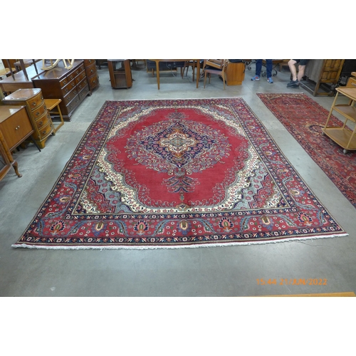 43 - A Persian red ground Tabriz rug, 393 x 303cms