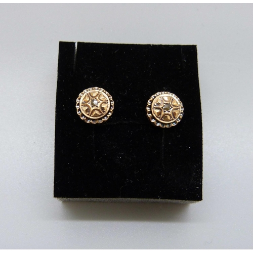 1057 - A pair of yellow metal earrings, each set with an old cut diamond, 1.4g