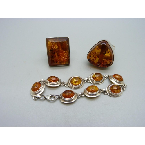 1070 - A silver and amber bracelet and two amber set rings, both Q