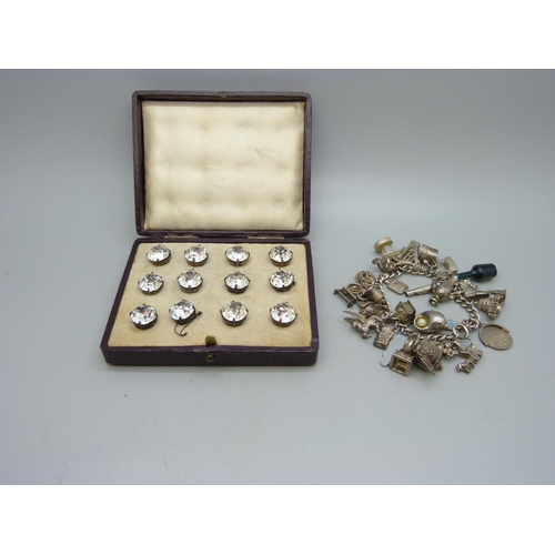 1095 - A charm bracelet and a set of twelve cased buttons