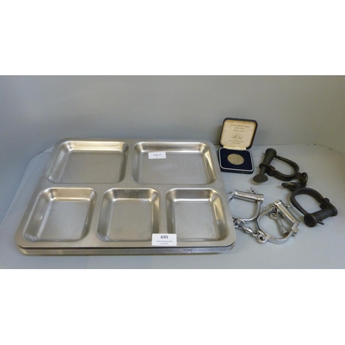 695 - Two pairs of handcuffs, eight prison trays and a Police medal