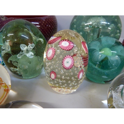 706 - Fourteen items of glass comprising ten glass paperweights, a heavy ruby red controlled glass ashtray... 