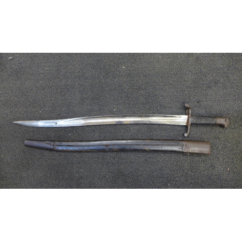 834 - A Victorian military bayonet with scabbard, marks including WD with broad arrow