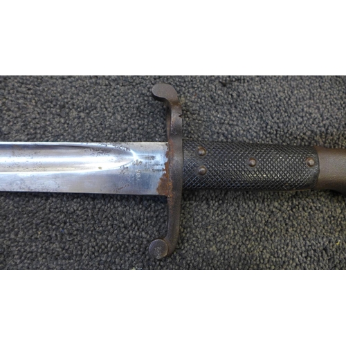 834 - A Victorian military bayonet with scabbard, marks including WD with broad arrow